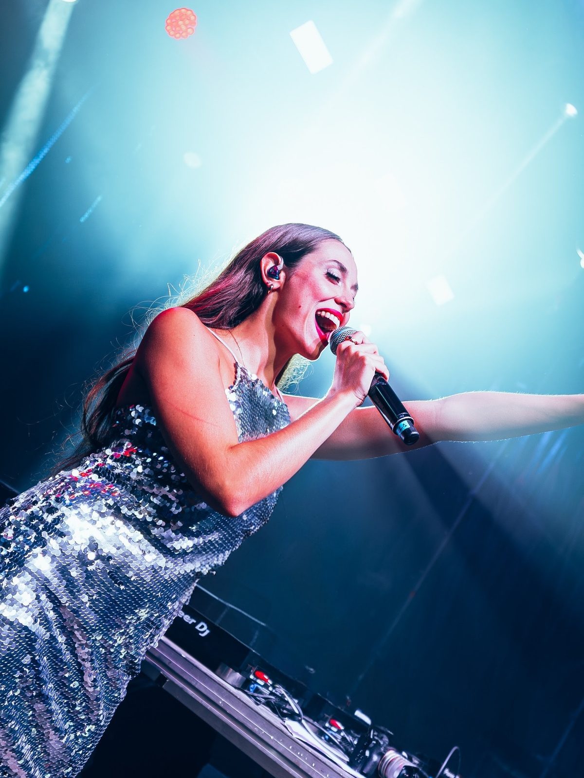 Gloria Monzonis cantando en directo con vestido de lentejuelas plateado